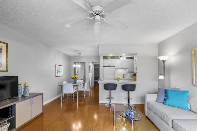 living room featuring dark hardwood / wood-style floors, a textured ceiling, and ceiling fan