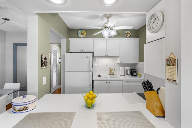 kitchen featuring sink, white appliances, ceiling fan, white cabinetry, and decorative backsplash