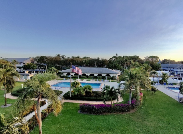 view of pool featuring a lawn