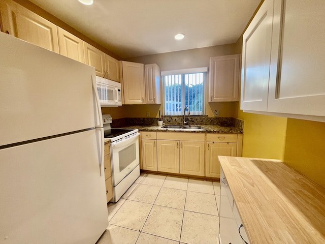 kitchen featuring sink, white appliances, and light tile patterned flooring