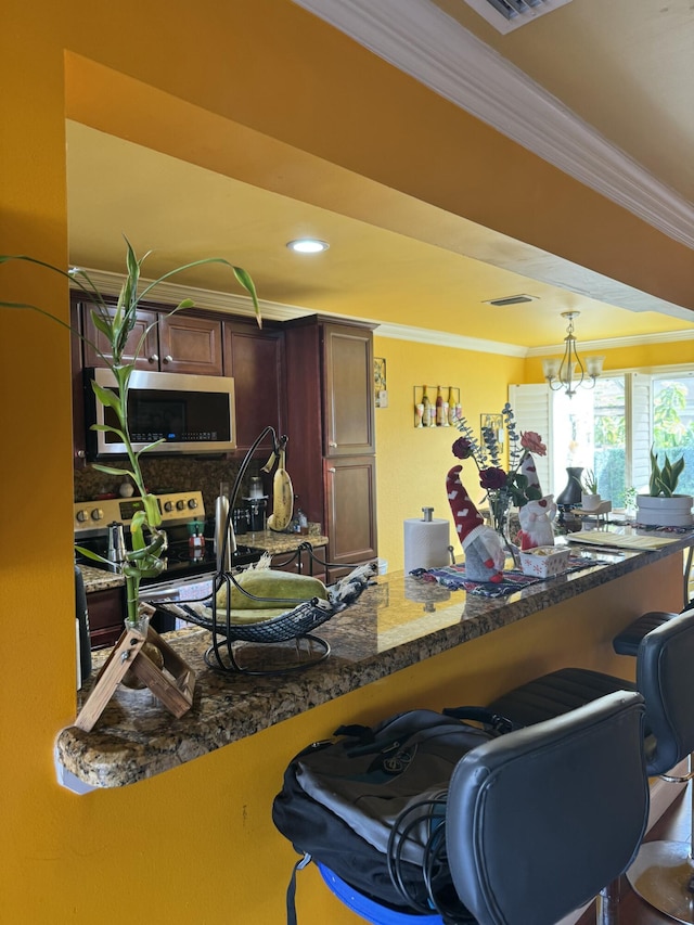 interior space featuring pendant lighting, crown molding, dark stone countertops, backsplash, and stainless steel appliances