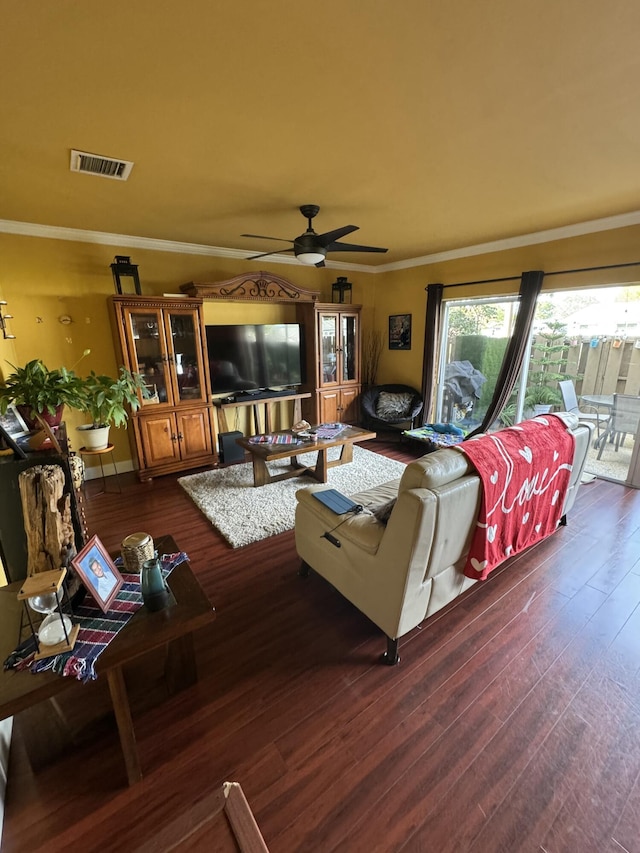 living room featuring dark wood-type flooring, ceiling fan, and ornamental molding