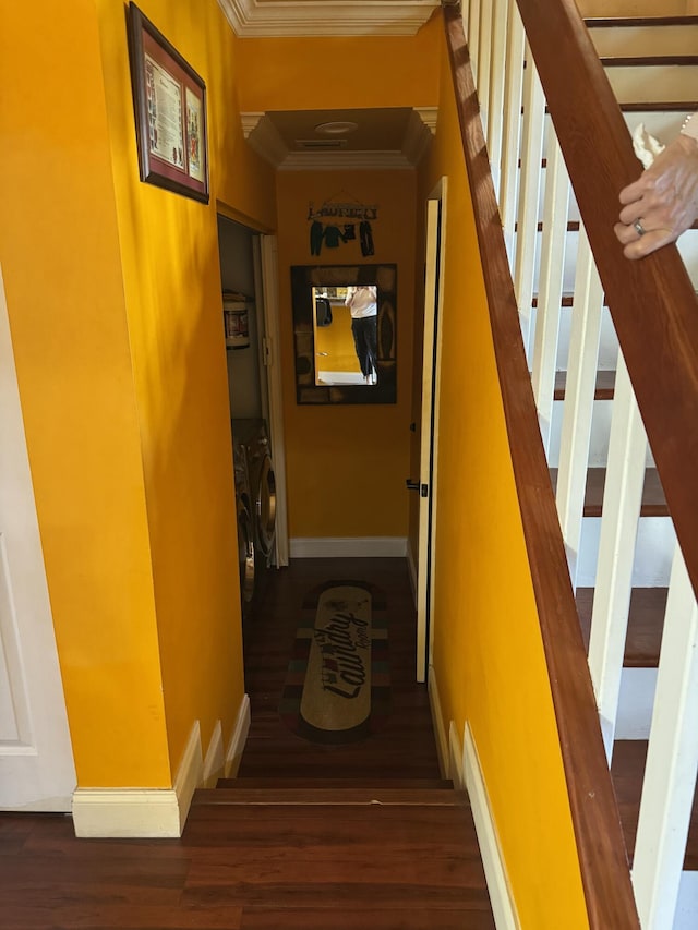 stairs with hardwood / wood-style flooring, ornamental molding, and washer / dryer