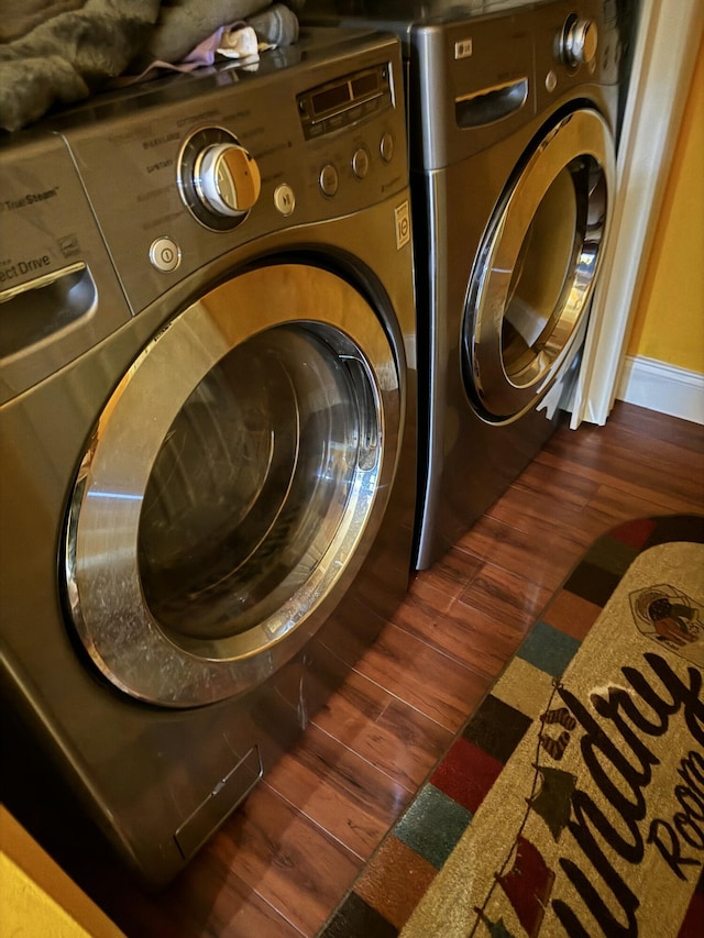 clothes washing area featuring dark hardwood / wood-style floors and washing machine and dryer