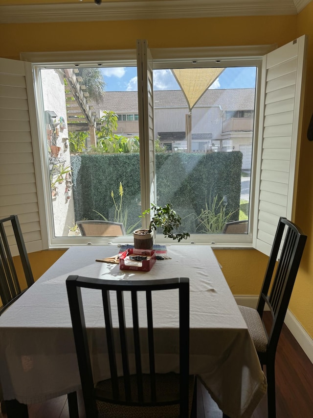 dining room with crown molding, plenty of natural light, and hardwood / wood-style floors