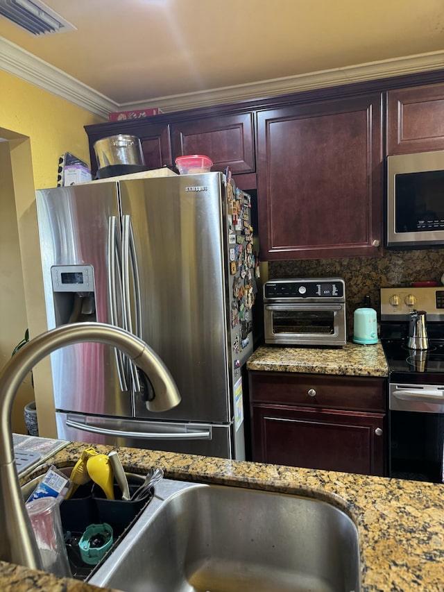 kitchen featuring ornamental molding, appliances with stainless steel finishes, light stone counters, and decorative backsplash