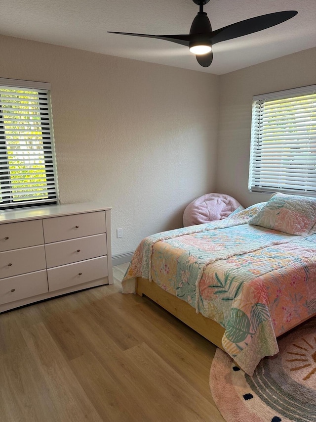 bedroom with ceiling fan and light hardwood / wood-style flooring