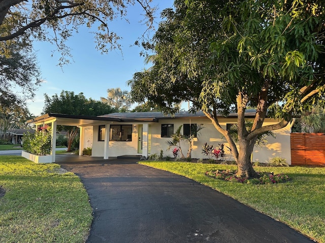 view of front of property featuring a front lawn and a carport