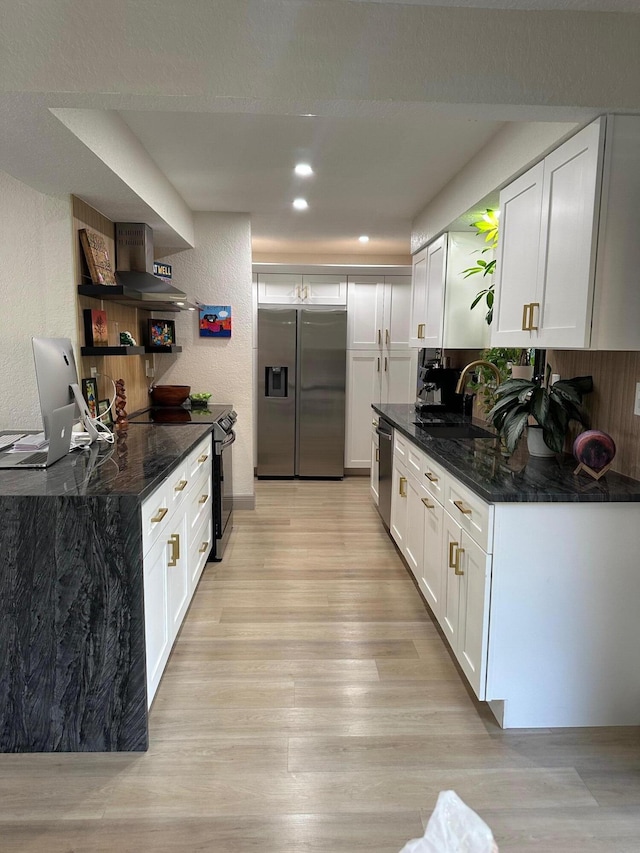 kitchen with white cabinetry, stainless steel appliances, sink, and dark stone counters