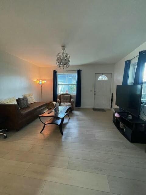 living room with a notable chandelier and light hardwood / wood-style flooring