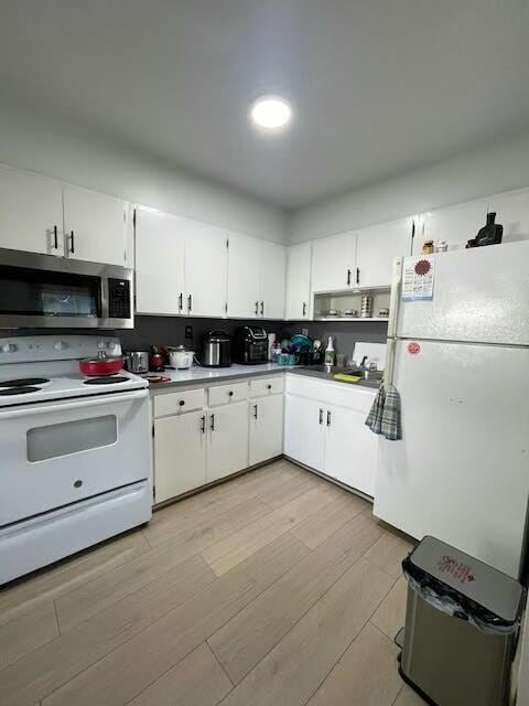 kitchen featuring decorative backsplash, white cabinets, white appliances, and light hardwood / wood-style floors