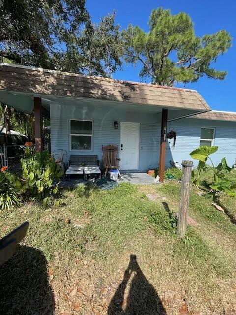 rear view of property with a yard and covered porch