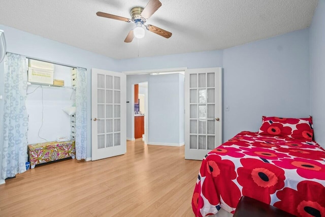 bedroom featuring a textured ceiling, light hardwood / wood-style floors, and french doors