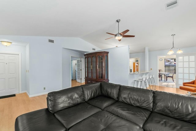 living room with ceiling fan, lofted ceiling, and light wood-type flooring