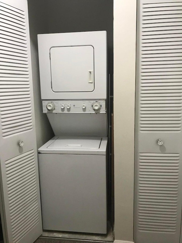 laundry room featuring stacked washer / drying machine