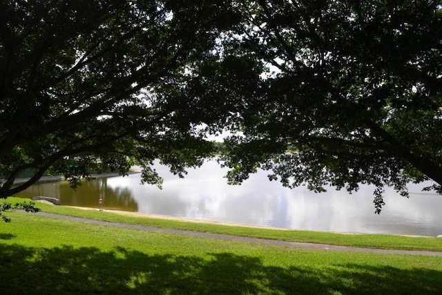 view of community with a yard and a water view