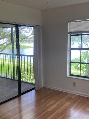 spare room with hardwood / wood-style flooring and a water view