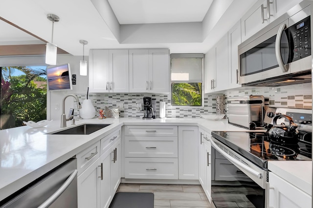 kitchen with white cabinetry, sink, pendant lighting, and appliances with stainless steel finishes