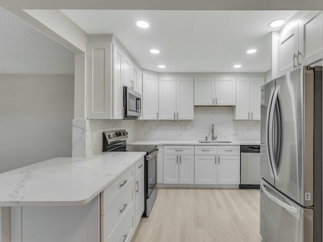 2030 Hythe B 2030, Boca Raton, FL 33434 - kitchen with sink, white cabinetry, stainless steel appliances, light stone counters, and kitchen peninsula