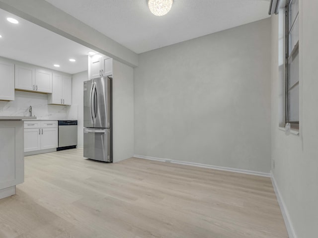 2030 Hythe B 2030, Boca Raton, FL 33434 - kitchen featuring sink, light hardwood / wood-style flooring, appliances with stainless steel finishes, white cabinets, and decorative backsplash