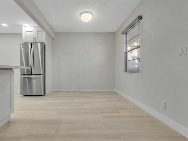 2030 Hythe B 2030, Boca Raton, FL 33434 - kitchen featuring a textured ceiling, stainless steel fridge, white cabinets, and light wood-type flooring