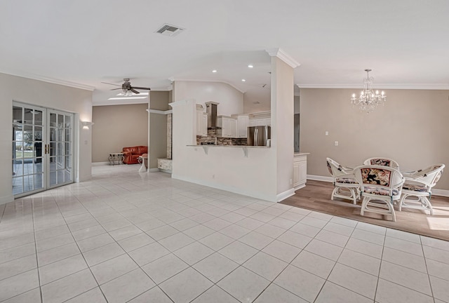 unfurnished living room featuring light tile patterned floors, crown molding, and ceiling fan with notable chandelier