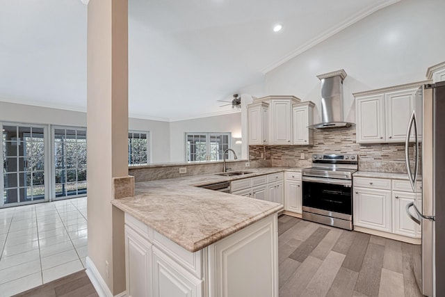 kitchen featuring kitchen peninsula, sink, backsplash, appliances with stainless steel finishes, and wall chimney exhaust hood