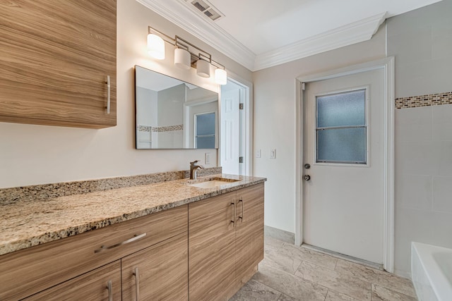 bathroom featuring a tub, vanity, and crown molding