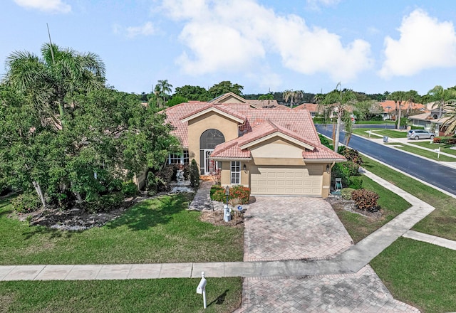 mediterranean / spanish home featuring a front lawn and a garage