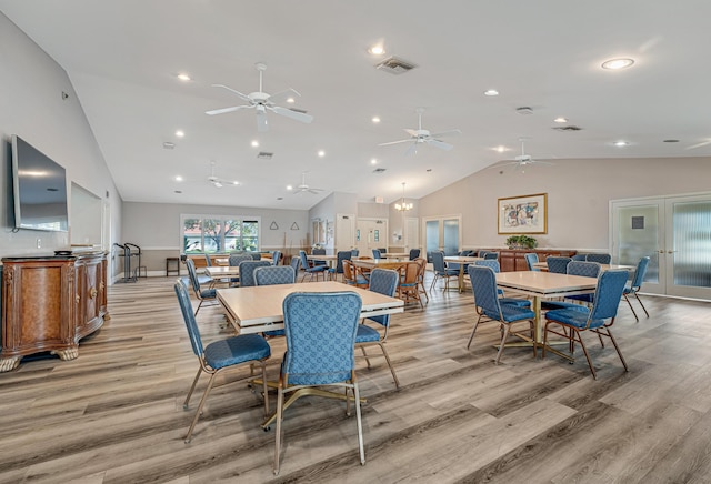 dining space with an inviting chandelier, light hardwood / wood-style flooring, and lofted ceiling