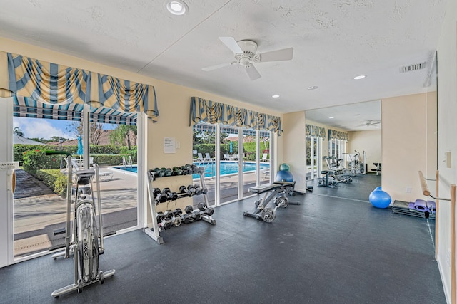 gym with a textured ceiling and ceiling fan