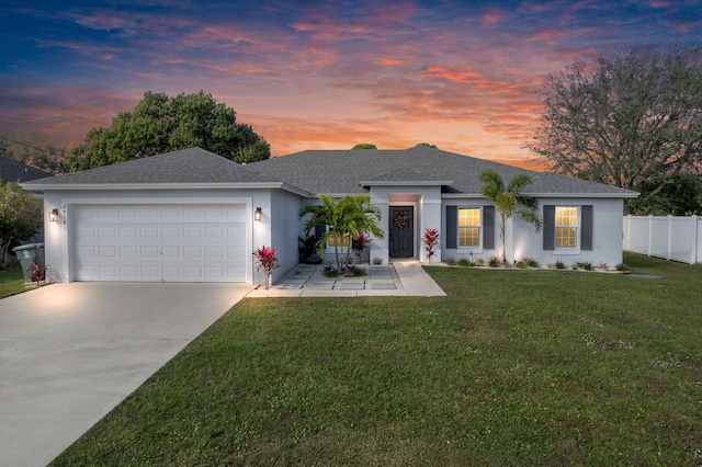 single story home featuring a garage and a yard