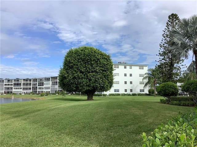 surrounding community featuring a water view and a lawn