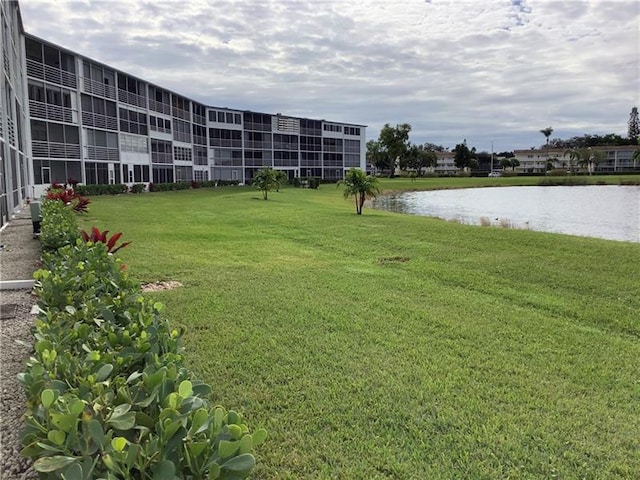 surrounding community with a lawn and a water view