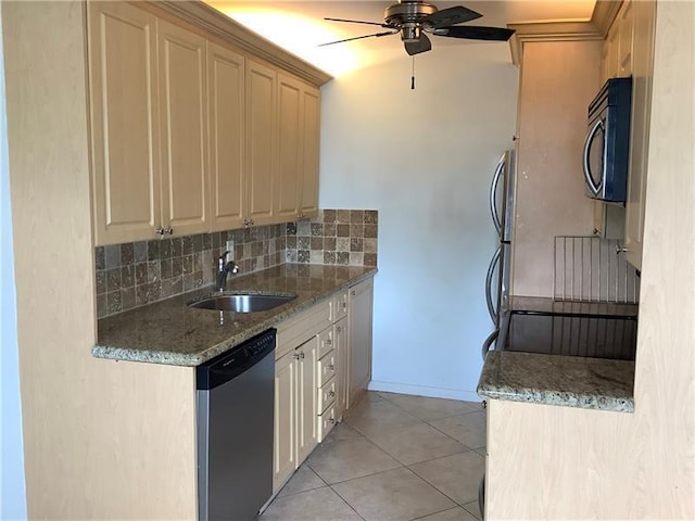 kitchen featuring appliances with stainless steel finishes, sink, decorative backsplash, light tile patterned floors, and light stone counters