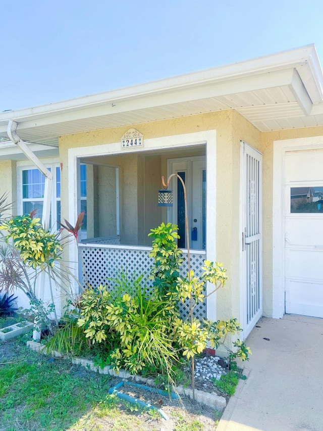 view of exterior entry featuring stucco siding