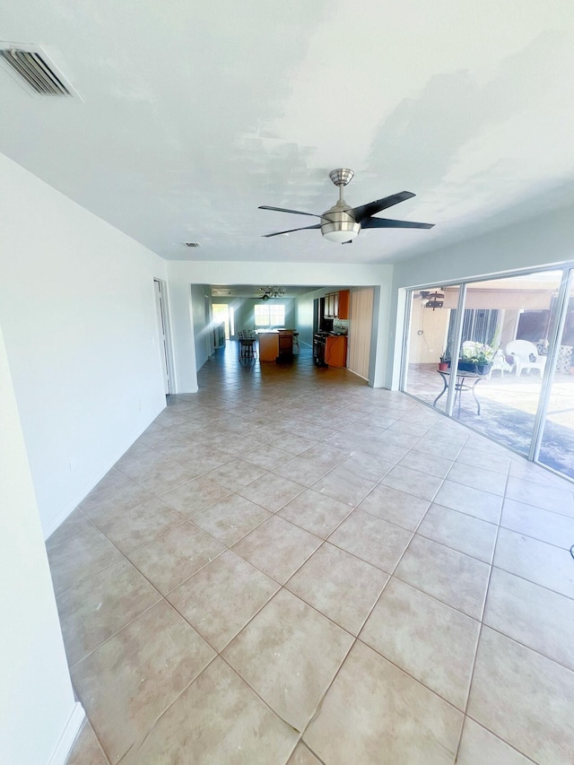 unfurnished living room with light tile patterned flooring, visible vents, and a ceiling fan