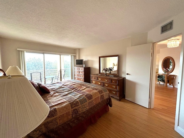 bedroom with a textured ceiling and light wood-type flooring