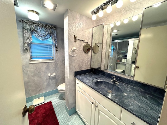 bathroom featuring vanity, a shower with door, tile patterned floors, and toilet