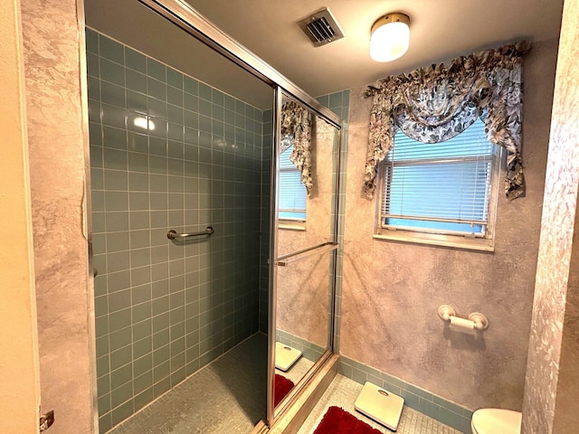 bathroom with tile patterned floors, toilet, and walk in shower