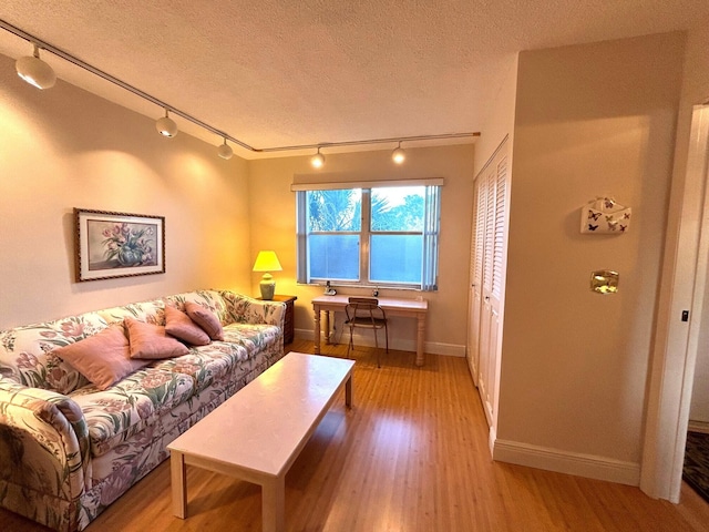 living room featuring a textured ceiling and light hardwood / wood-style floors