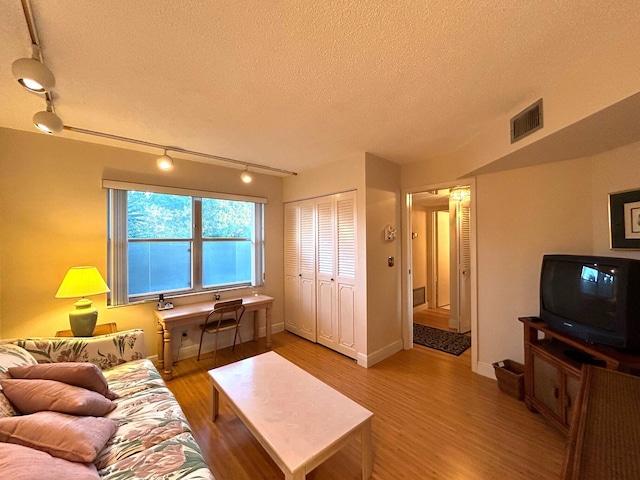 living room with light hardwood / wood-style flooring and a textured ceiling