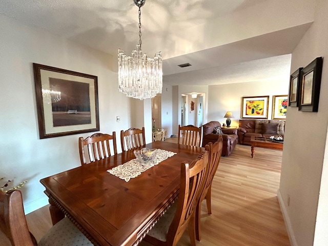 dining area featuring a chandelier and light hardwood / wood-style floors