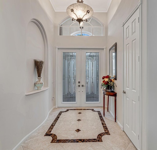 foyer entrance featuring crown molding, a chandelier, and french doors