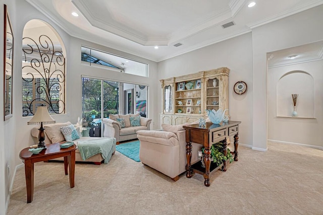 tiled living room featuring ornamental molding, a raised ceiling, and a high ceiling