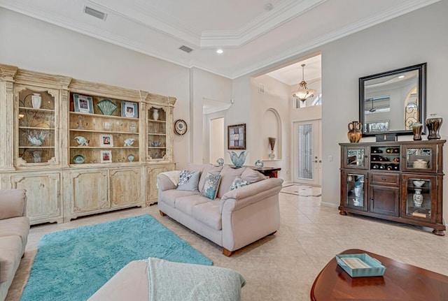 living room with crown molding, light tile patterned floors, and a tray ceiling