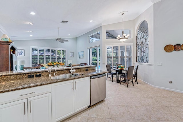 kitchen with sink, white cabinetry, decorative light fixtures, dark stone countertops, and stainless steel dishwasher