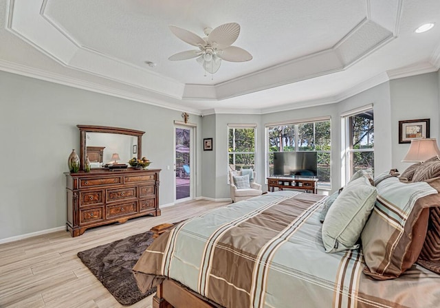 bedroom with access to exterior, ceiling fan, light hardwood / wood-style floors, a raised ceiling, and crown molding