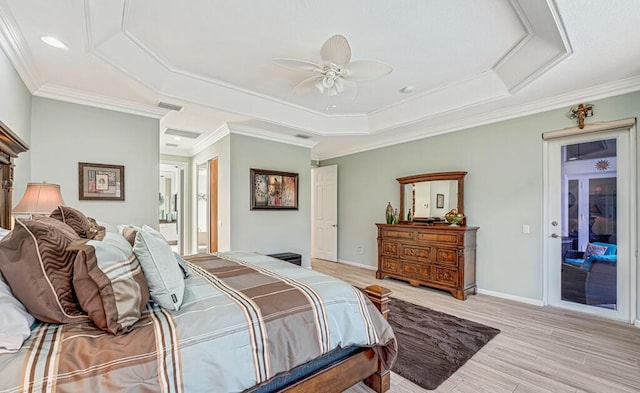 bedroom with crown molding, a tray ceiling, light hardwood / wood-style flooring, and ceiling fan