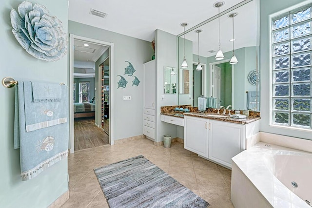 bathroom with vanity, a washtub, plenty of natural light, and tile patterned floors